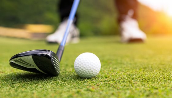 A person getting ready to hit a golf ball.